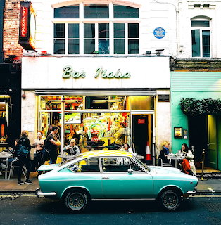 Bar Italia cafe storefront with turquoise vintage car parked outside and people at sidewalk tables