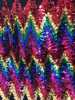 Close-up of colorful sequins forming a zigzag chevron pattern on fabric