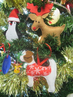Felt Christmas ornaments of animals and angel on green tinsel garland