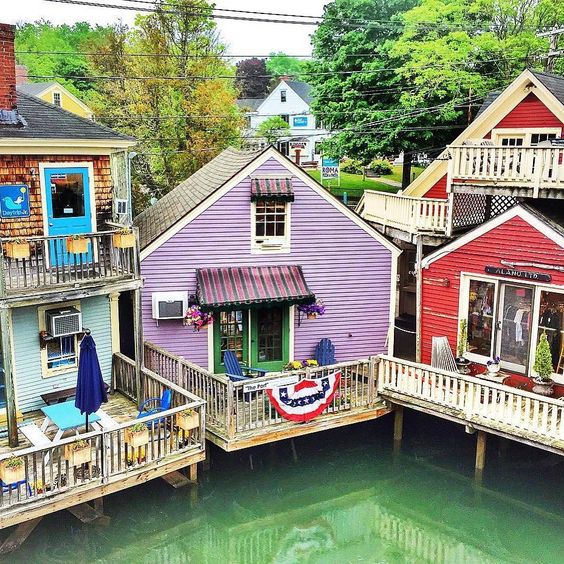 Colorful houses on stilts over green water in coastal village