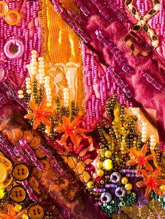 Colorful abstract textile collage with beads, buttons, sequins, and pink-orange fabric