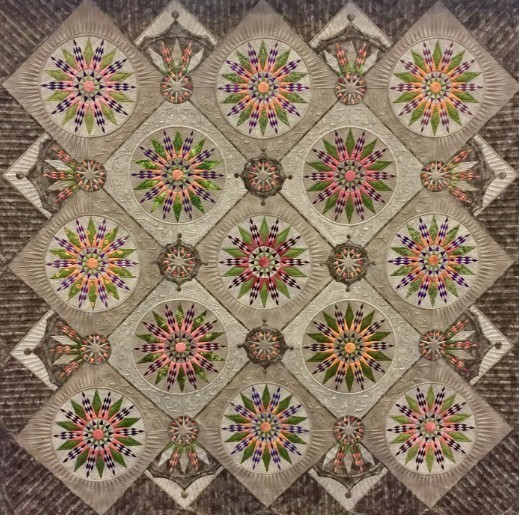 Colorful compass-style quilt pattern with geometric patchwork blocks on a brown background
