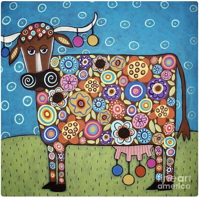 Colorful folk art cow with floral and circular patterns on grass against a blue background