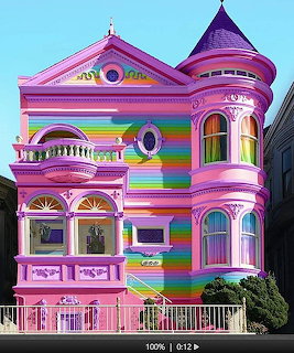 Rainbow-striped Victorian house with turret and ornate decorative trim in pastel colors
