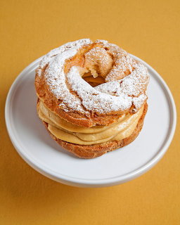 Paris-Brest pastry with powdered sugar on white plate