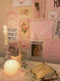 Pink coquette wall collage with vintage postcards, envelopes, Harry Styles poster, lit candles, and a slice of cake