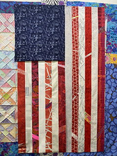 Handmade quilt with American flag design in red, white and blue fabrics with decorative patchwork border