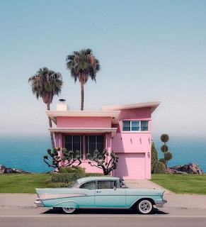 Pink beach house with palm trees and vintage turquoise car against ocean backdrop