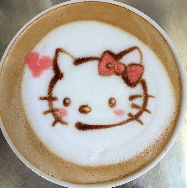 Coffee cup with Hello Kitty latte art in milk foam and a pink bow