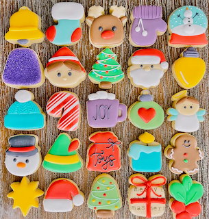 Assortment of decorated Christmas cookies in festive shapes on rustic wood surface