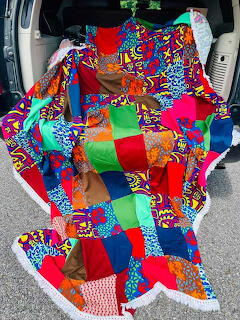 Colorful patchwork quilt with geometric patterns draped over car seat