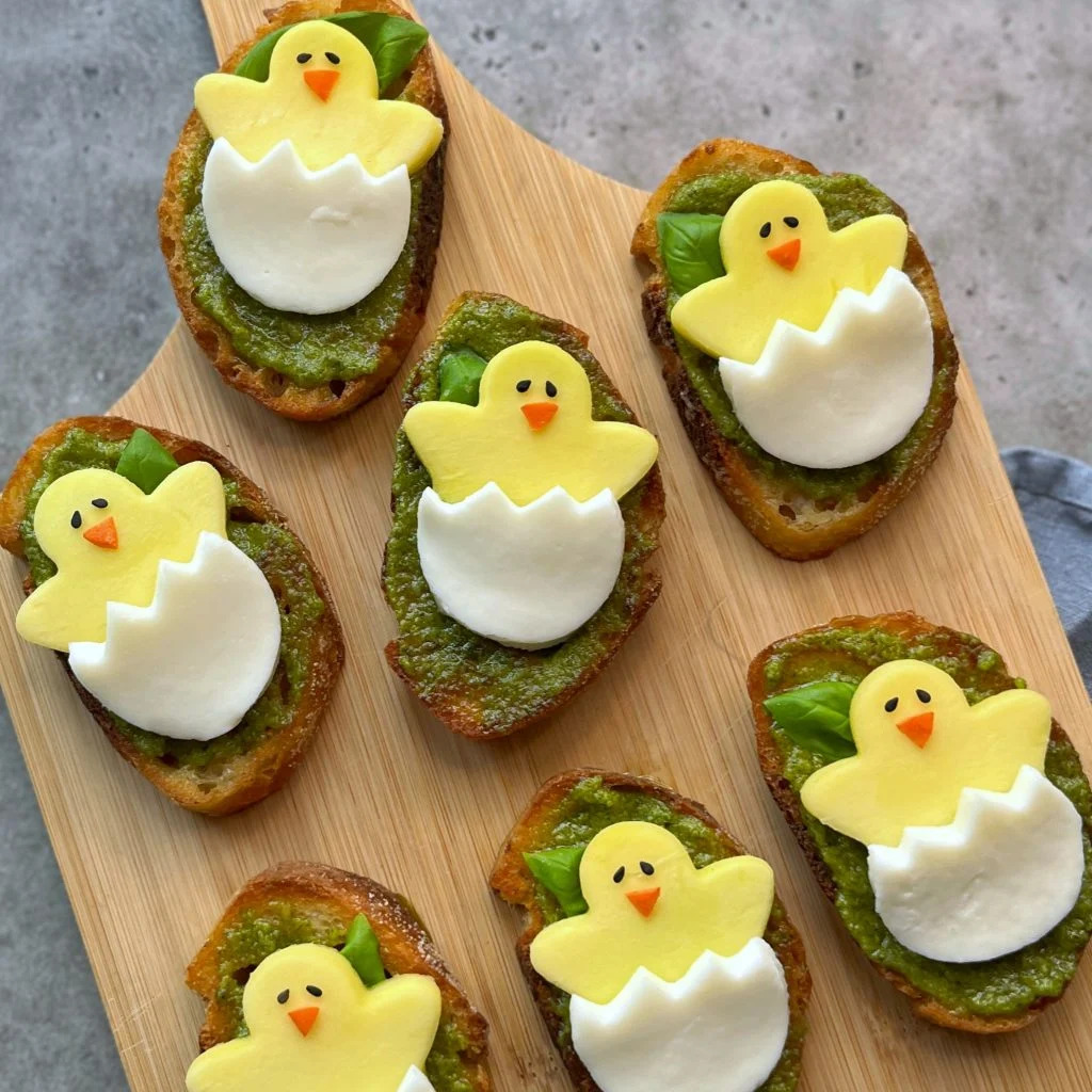 Easter-themed crostini with chick decorations on a wooden serving board