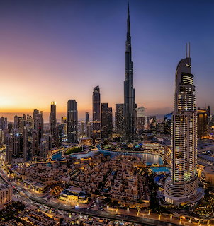 Dubai downtown skyline at sunset with Burj Khalifa towering above illuminated skyscrapers