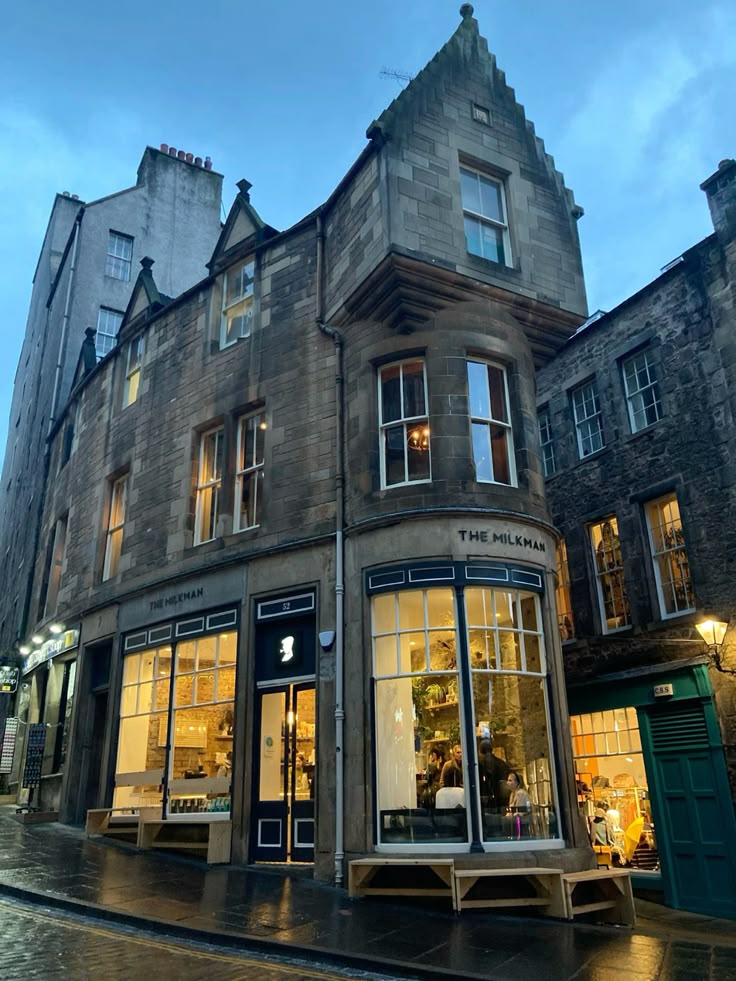 Dark wooden exterior of The Milkman cafe in Edinburgh with vintage signage and stone facade.