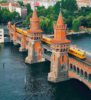 Oberbaum Bridge with red towers and yellow train crossing the Spree River in Berlin