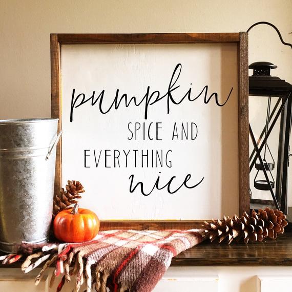 Rustic wooden framed sign with pumpkin spice quote, autumn decorations including small pumpkin and pinecones