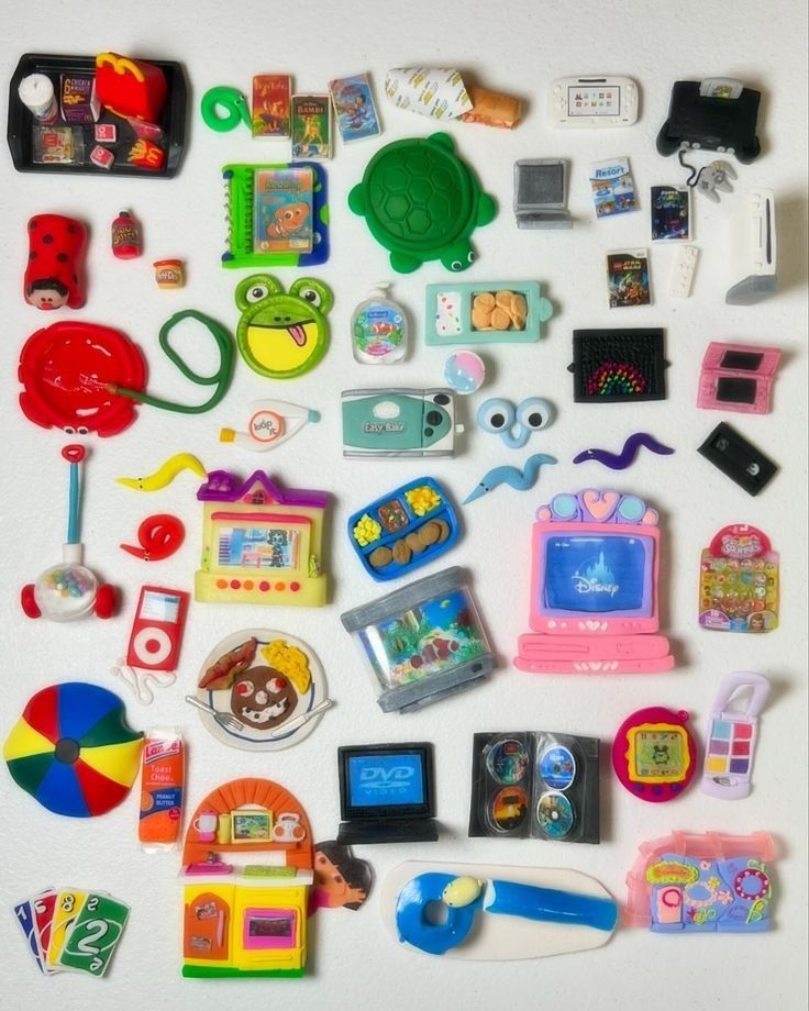 Colorful collection of small toy trinkets and miniature gadgets on a white background