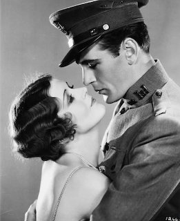 Black and white vintage photo of a military man in uniform embracing a glamorous woman