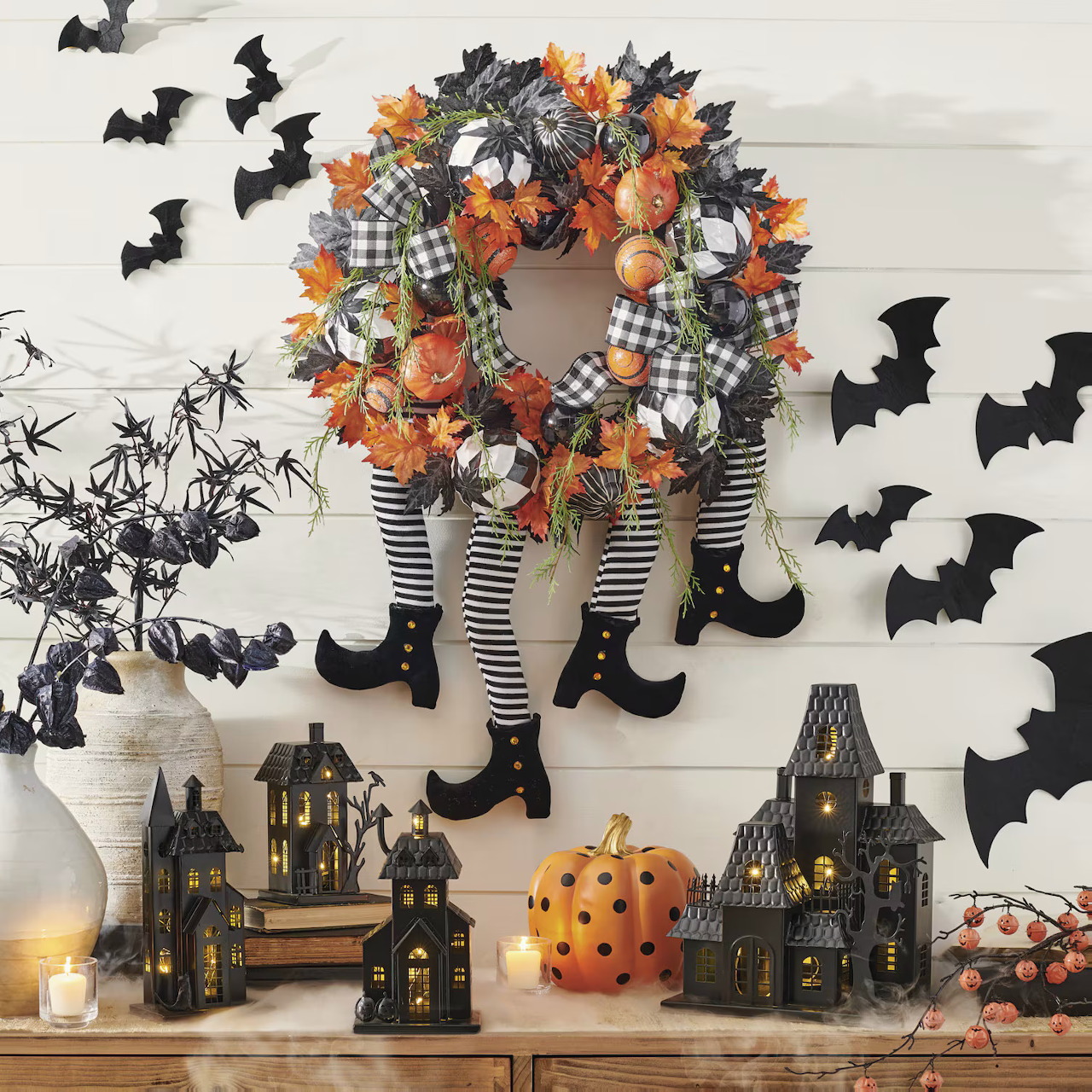 Halloween fall centerpiece with wreath, striped witch legs, bats, pumpkins, and miniature haunted houses