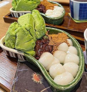 Matcha mochi dessert with dango balls, red bean paste, and kinako powder on bamboo leaf