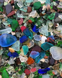 Collection of multicolored sea glass fragments including green, blue, brown and frosted pieces