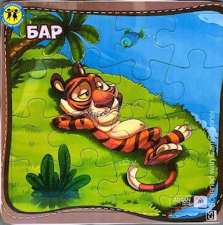 Smiling cartoon tiger resting on green grass under palm tree with blue sky and butterfly