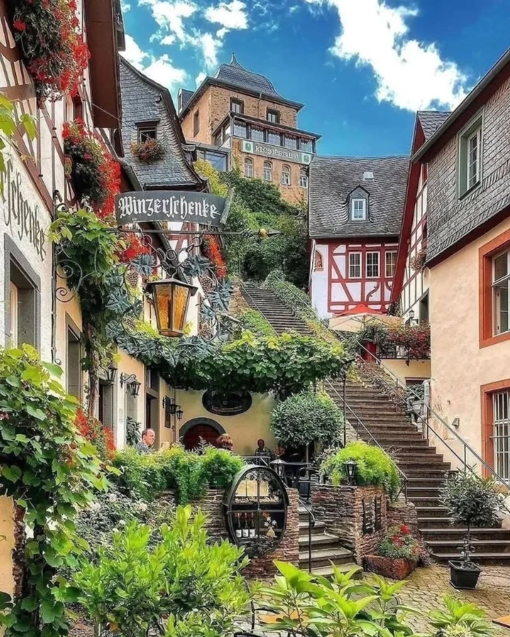 Charming cobblestone street in Beilstein, Germany with historic buildings, stone stairs, flowers and greenery