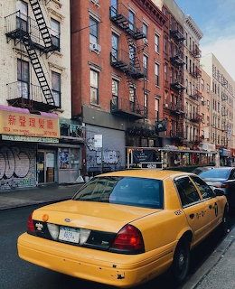 Yellow taxi cab parked on urban street with red brick buildings