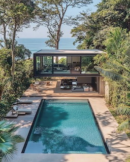 Modern tropical villa with rectangular pool surrounded by trees near the ocean