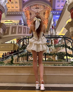 Woman in white dress viewing decorated shopping mall from balcony
