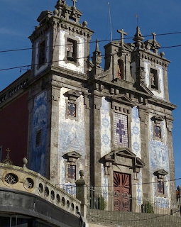 Historic Baroque church in Porto covered in blue and white azulejo tiles, with twin bell towers