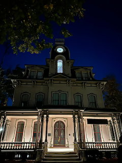 Historic illuminated house with a clock tower at night