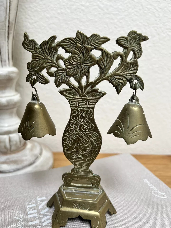 Ornate antique brass vase ornament with engraved floral motifs and two hanging bells