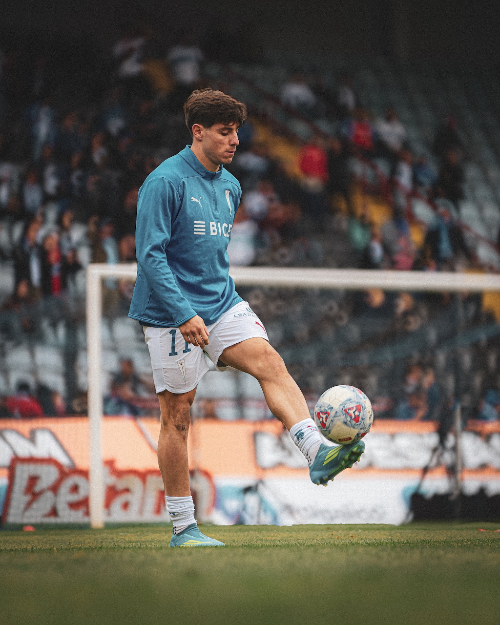 Soccer player Clemente Montes juggling a ball during warmup on a grass field