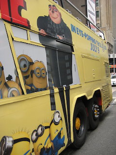 Yellow bus painted with Minions characters on city street