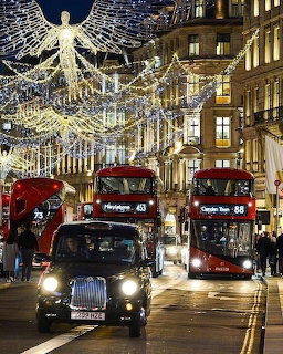 Regent Street at night with Christmas angel lights, red buses and black taxi