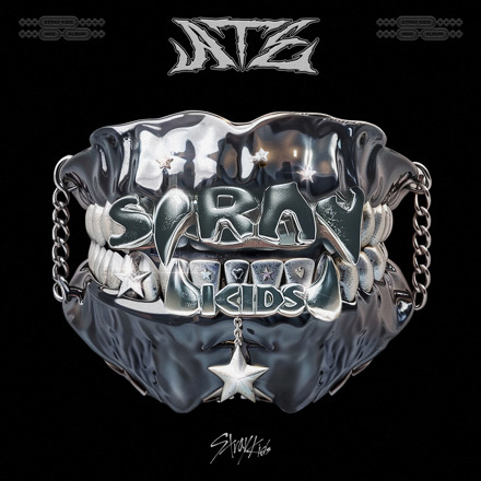 Shiny metal grillz with 'Stray Kids' engraved lettering and a star pendant on dark background