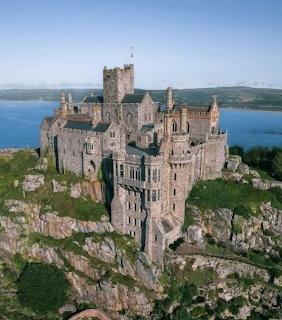 Aerial view of St Michael's Mount castle on rocky island surrounded by blue sea