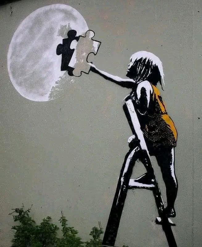 Street art of a girl on a ladder painting a jigsaw piece into the moon