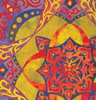 Colorful quilt with red and blue mandala motifs on yellow and orange patterned background with swirling designs