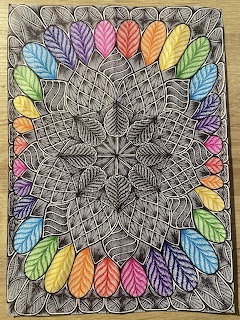 Intricate zentangle mandala with black and white patterns surrounded by colorful rainbow leaves