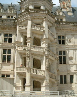 Ornate open spiral staircase on the exterior facade of Chateau de Blois with carved stone details