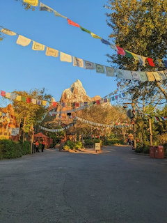 Mountain attraction with colorful prayer flags and trees against blue sky