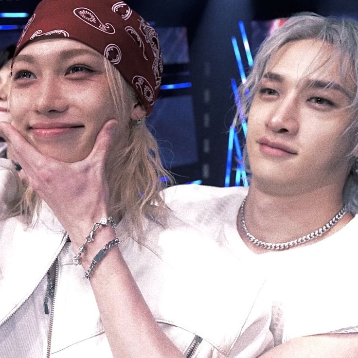 Close-up of two young performers in white clothing under blue stage lights