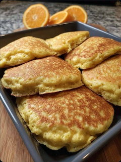 Golden Mexican patties on a tray with orange slices