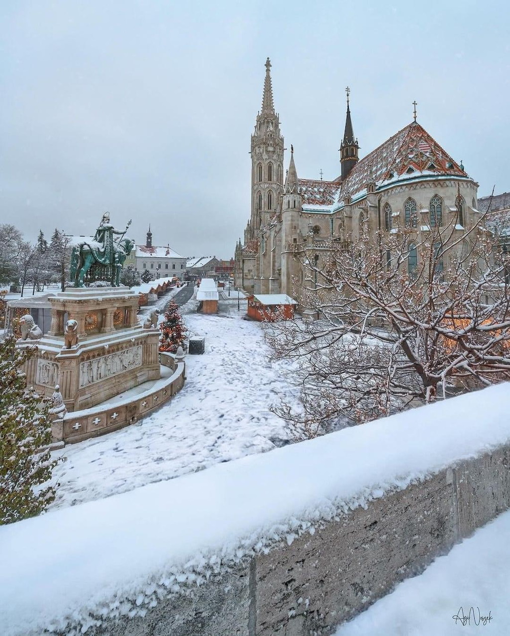 Snow-covered Buda Castle with Matthias Church spire and fortress walls in Budapest during winter
