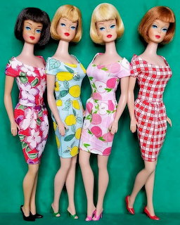 Four vintage Barbie dolls in retro patterned dresses on turquoise background