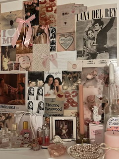 Pink aesthetic wall collage with magazine clippings, photos, perfume bottles, pearls, and candles on a vanity