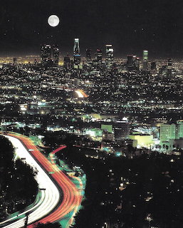 Los Angeles city skyline at night with full moon and freway light trails
