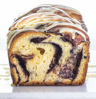 Front view of a glazed loaf cake with chocolate swirls on a white background